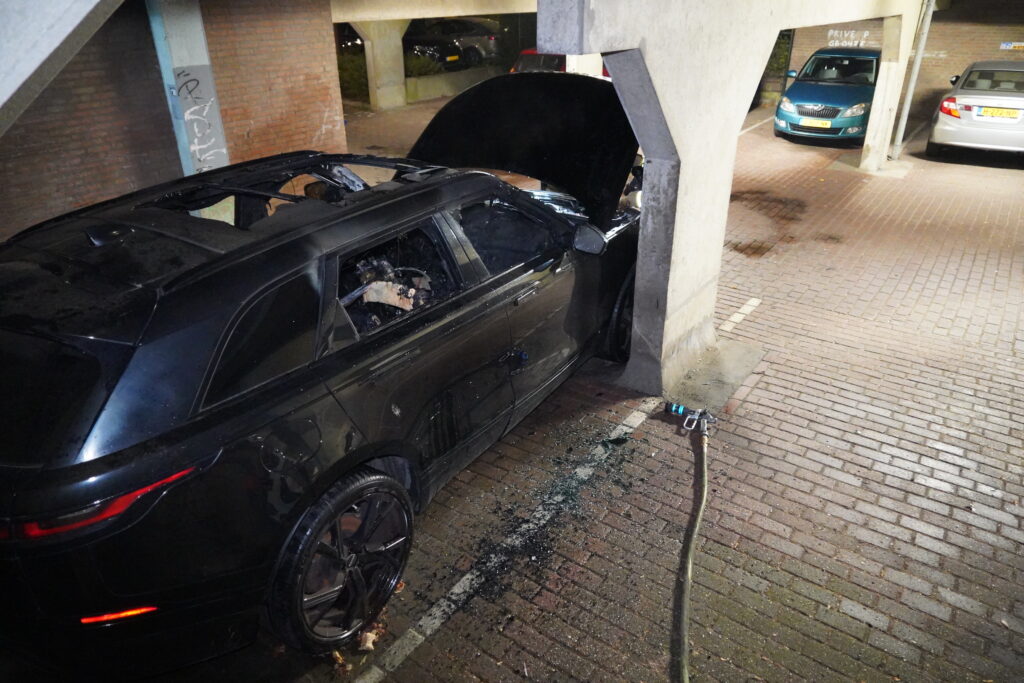 Geparkeerde auto verwoest door brand onder appartementencomplex Parkdreef